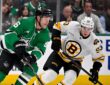 Dallas Stars right wing Mikko Rantanen carries the puck up ice as Boston Bruins center Fraser Minten skates alongside.