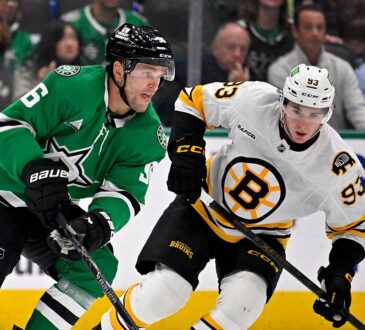 Dallas Stars right wing Mikko Rantanen carries the puck up ice as Boston Bruins center Fraser Minten skates alongside.