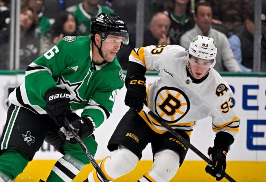 Dallas Stars right wing Mikko Rantanen carries the puck up ice as Boston Bruins center Fraser Minten skates alongside.