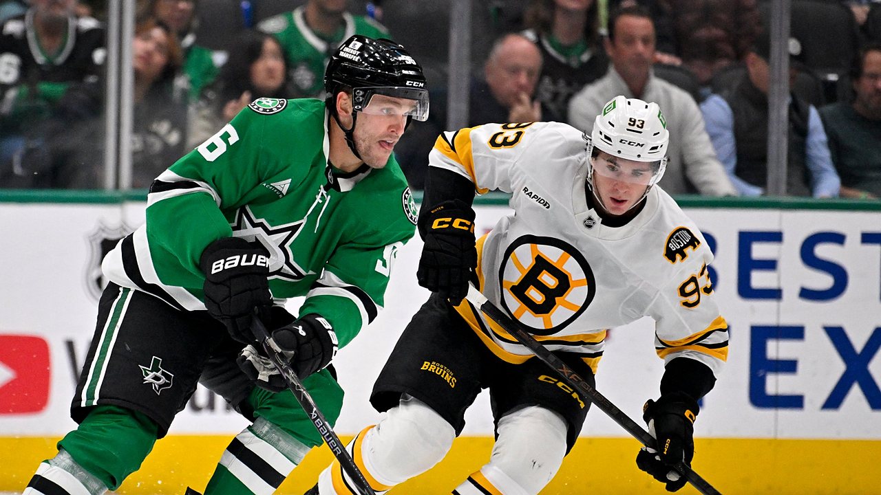 Dallas Stars right wing Mikko Rantanen carries the puck up ice as Boston Bruins center Fraser Minten skates alongside.