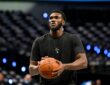 Dallas Mavericks center Moussa Cissé holds a basketball at his chest during pregame warmups in a black team T-shirt.