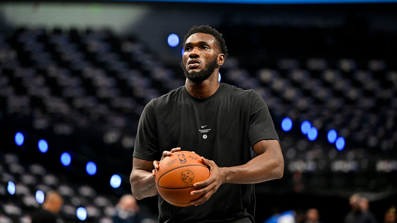 Dallas Mavericks center Moussa Cissé holds a basketball at his chest during pregame warmups in a black team T-shirt.