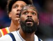 Mavericks forward Naji Marshall looks up as a Hawks player watches behind him.
