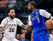 Dallas Mavericks forward Naji Marshall dribbles as San Antonio Spurs forward Julian Champagnie defends.