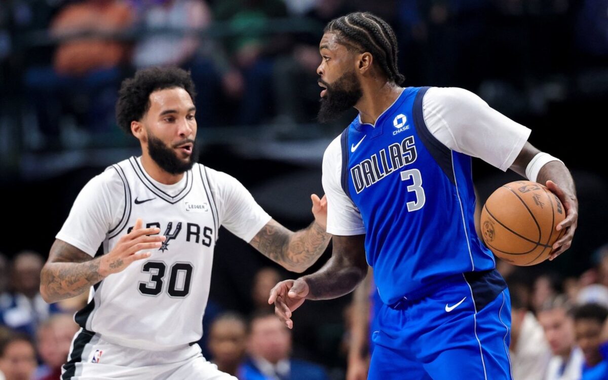 Dallas Mavericks forward Naji Marshall dribbles as San Antonio Spurs forward Julian Champagnie defends.