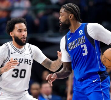 Dallas Mavericks forward Naji Marshall dribbles as San Antonio Spurs forward Julian Champagnie defends.