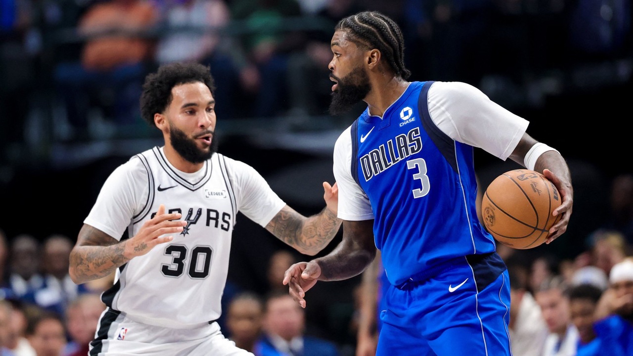 Dallas Mavericks forward Naji Marshall dribbles as San Antonio Spurs forward Julian Champagnie defends.