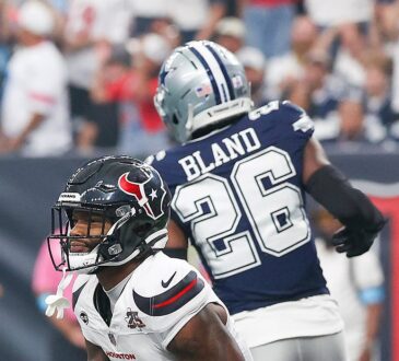 Texans wide receiver Nico Collins kneels in the end zone with the ball as Cowboys cornerback DaRon Bland turns away.