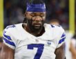 Dallas Cowboys linebacker Rashan Gary looks down on the field wearing a team skull cap and eye black.