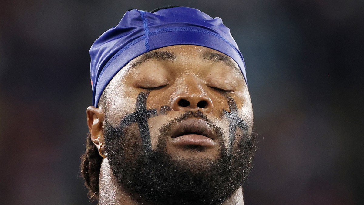 Dallas Cowboys linebacker Rashan Gary closes his eyes in a tight close-up, wearing eye black and a blue skull cap.