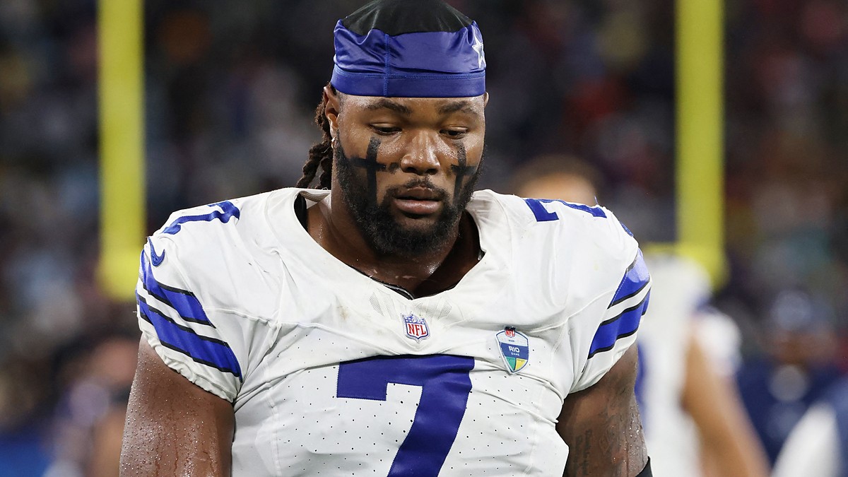 Dallas Cowboys linebacker Rashan Gary looks down on the field wearing a team skull cap and eye black.
