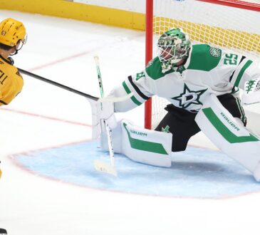 Penguins right wing Rickard Rakell shoots past Stars goaltender Jake Oettinger, who stretches into a split in the crease.
