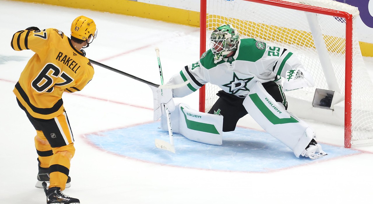 Penguins right wing Rickard Rakell shoots past Stars goaltender Jake Oettinger, who stretches into a split in the crease.
