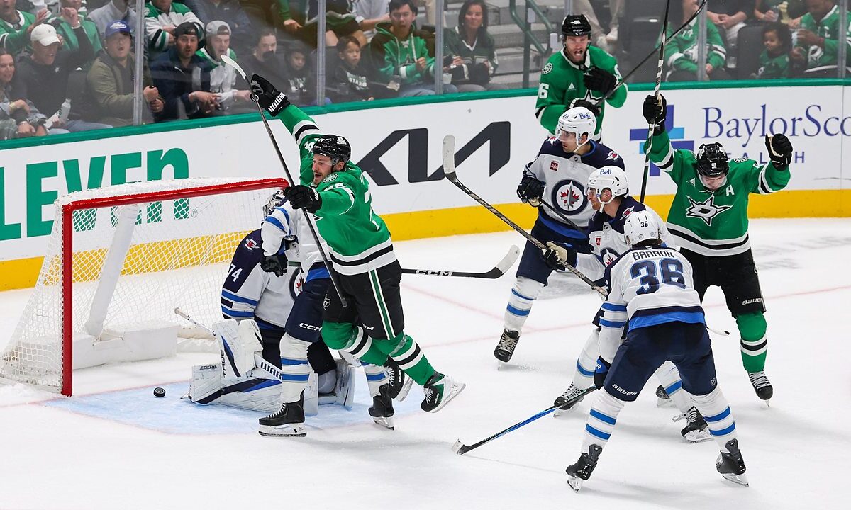 Dallas Stars center Roope Hintz leaps in celebration as the puck sits behind Winnipeg Jets goaltender Stuart Skinner.