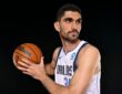 Dallas Mavericks forward-center Santi Aldama holds a basketball in shooting position and looks off to his left.