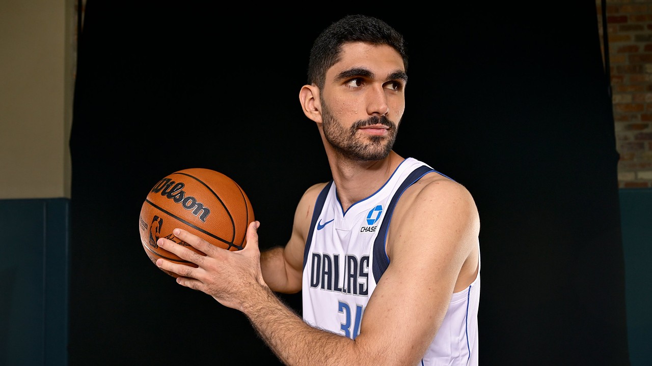 Dallas Mavericks forward-center Santi Aldama holds a basketball in shooting position and looks off to his left.