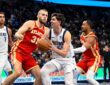 Dallas Mavericks forward Sergio de Larrea drives with the ball between Atlanta Hawks defenders as a teammate trails the play.