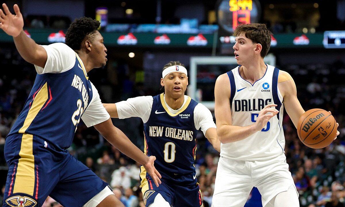 Dallas Mavericks guard Sergio de Larrea holds the ball as Pelicans guard Jeremiah Fears and center Derik Queen defend.