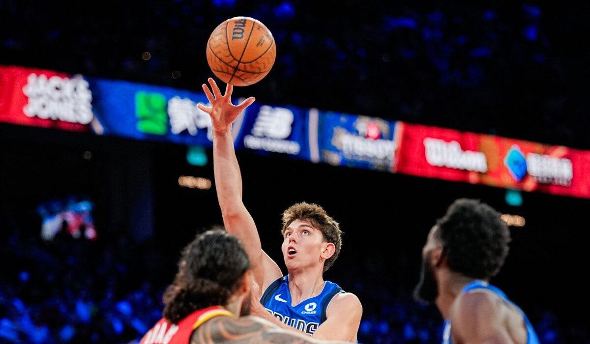 Mavericks guard Sergio De Larrea releases a floater over Rockets defenders, eyes locked on the ball.