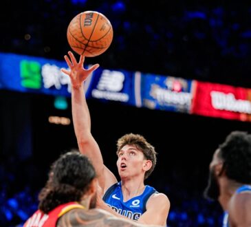 Mavericks guard Sergio De Larrea releases a floater over Rockets defenders, eyes locked on the ball.