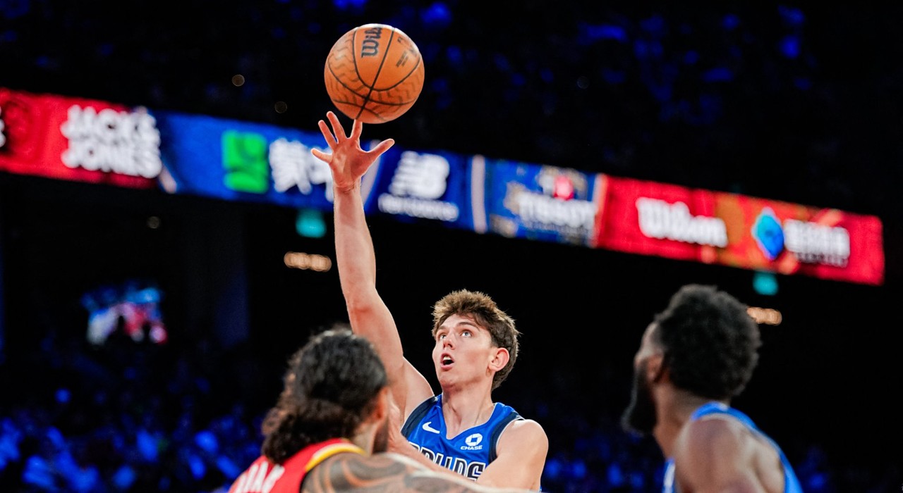 Mavericks guard Sergio De Larrea releases a floater over Rockets defenders, eyes locked on the ball.