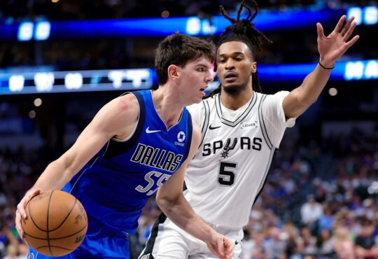 Dallas Mavericks guard Sergio de Larrea drives with the ball as San Antonio Spurs guard Stephon Castle defends with an arm raised.
