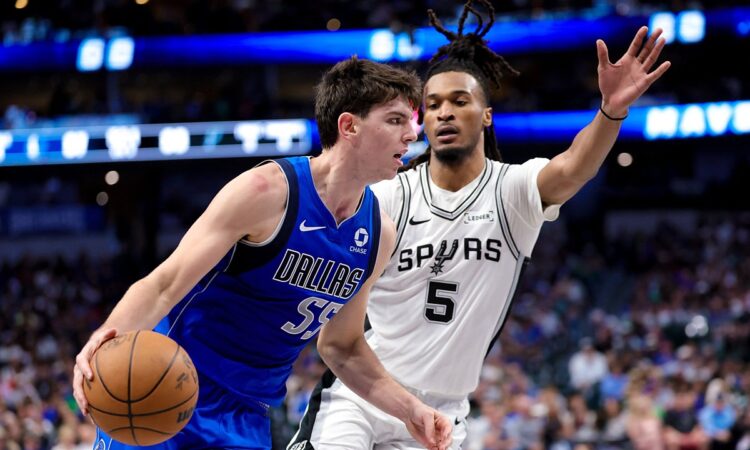 Dallas Mavericks guard Sergio de Larrea drives with the ball as San Antonio Spurs guard Stephon Castle defends with an arm raised.