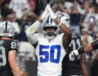 Dallas Cowboys linebacker Shemar James raises both hands over his helmet in a safety signal as Raiders players walk away.