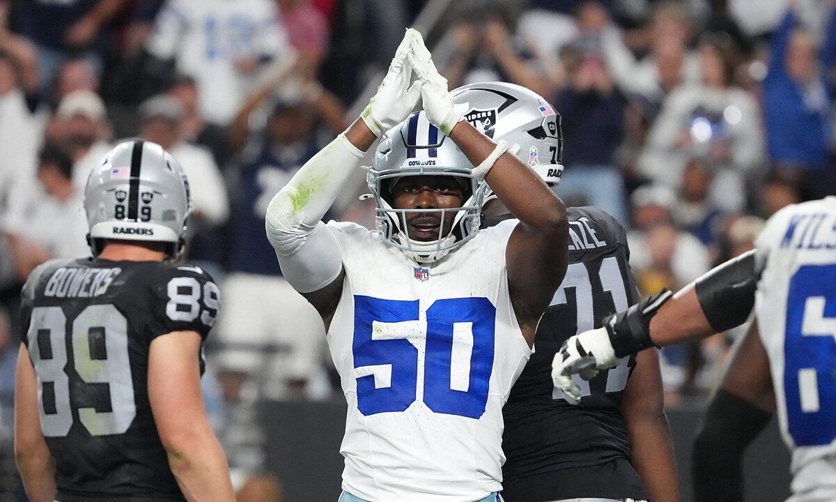 Dallas Cowboys linebacker Shemar James raises both hands over his helmet in a safety signal as Raiders players walk away.