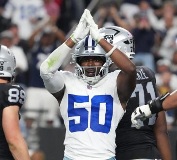 Dallas Cowboys linebacker Shemar James raises both hands over his helmet in a safety signal as Raiders players walk away.