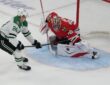 Chicago Blackhawks goaltender Spencer Knight drops into a split to stop a shot from Dallas Stars center Roope Hintz.