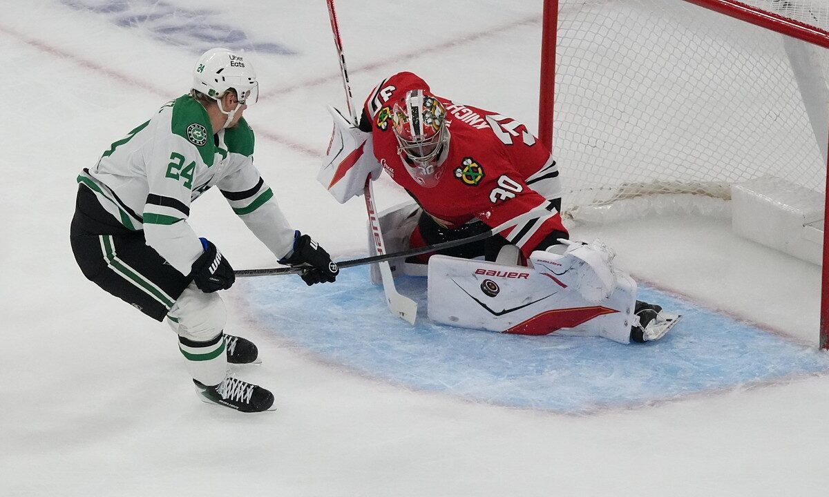 Chicago Blackhawks goaltender Spencer Knight drops into a split to stop a shot from Dallas Stars center Roope Hintz.