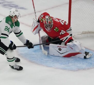 Chicago Blackhawks goaltender Spencer Knight drops into a split to stop a shot from Dallas Stars center Roope Hintz.