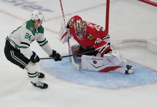 Chicago Blackhawks goaltender Spencer Knight drops into a split to stop a shot from Dallas Stars center Roope Hintz.