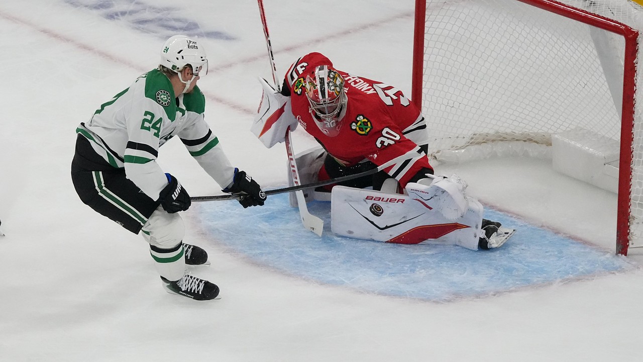 Chicago Blackhawks goaltender Spencer Knight drops into a split to stop a shot from Dallas Stars center Roope Hintz.