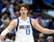 Mavericks forward Tarik Biberović gestures with both arms out during a game.