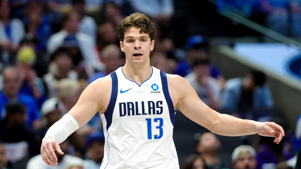 Mavericks forward Tarik Biberović gestures with both arms out during a game.