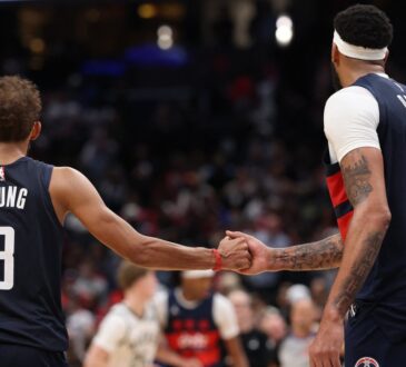 Washington Wizards guard Trae Young #3 celebrates with forward Anthony Davis #23 in the final minute against the Milwaukee Bucks at Capital One Arena.