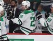 Stars center Tyler Seguin smiles as he bumps gloves with teammates along the bench after scoring.