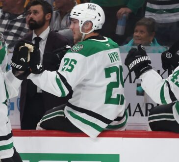 Stars center Tyler Seguin smiles as he bumps gloves with teammates along the bench after scoring.