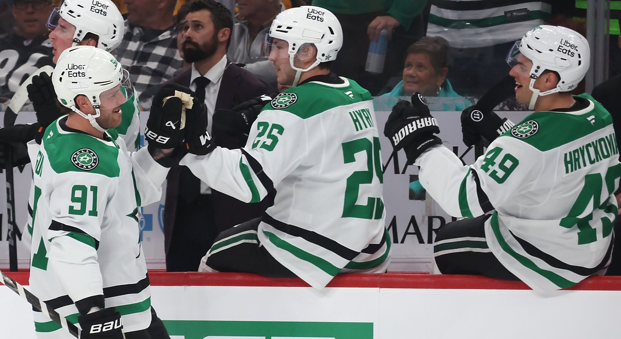 Stars center Tyler Seguin smiles as he bumps gloves with teammates along the bench after scoring.