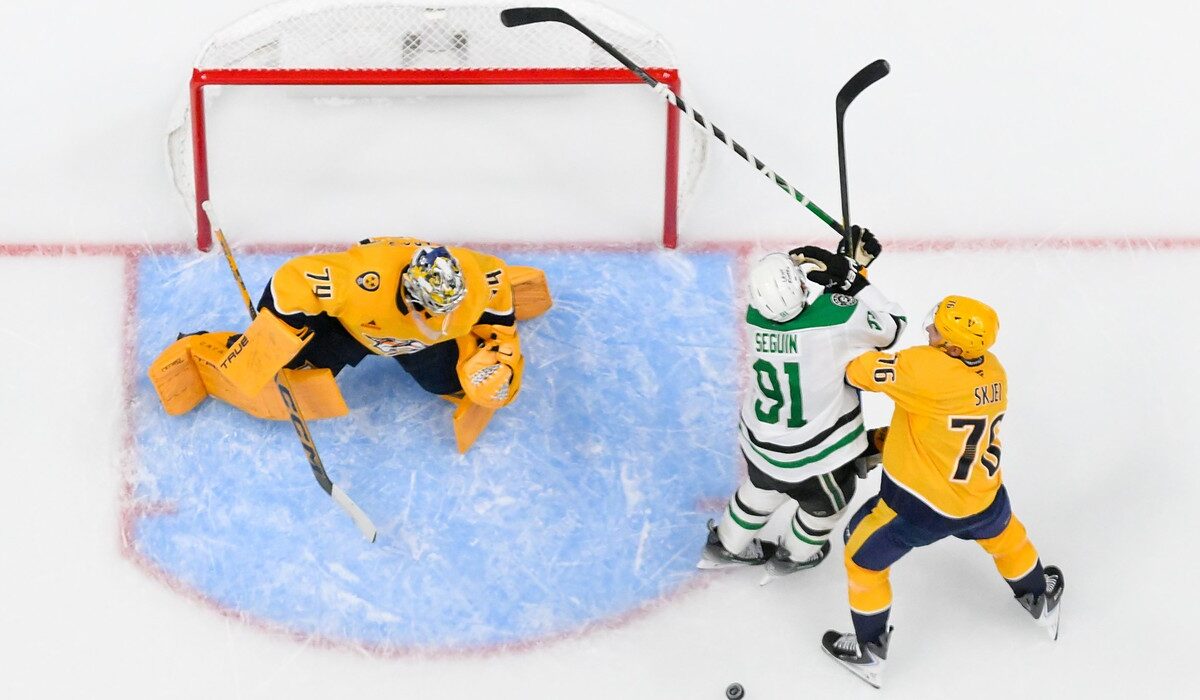 Stars center Tyler Seguin fights for position with Predators defenseman Brady Skjei beside the crease in an overhead view.