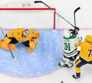 Stars center Tyler Seguin fights for position with Predators defenseman Brady Skjei beside the crease in an overhead view.