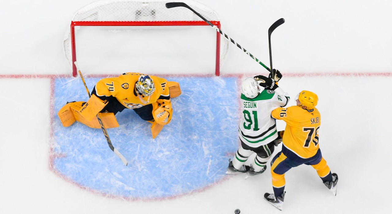 Stars center Tyler Seguin fights for position with Predators defenseman Brady Skjei beside the crease in an overhead view.