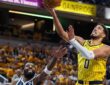 Indiana Pacers guard Tyrese Haliburton lays the ball up as Dallas Mavericks guard Kyrie Irving reaches up from below.