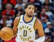 Indiana Pacers guard Tyrese Haliburton brings the ball upcourt with his right hand.