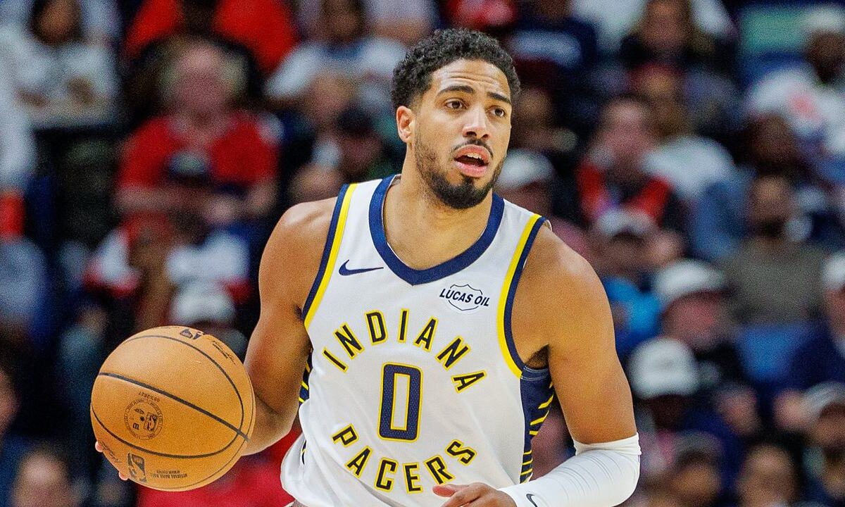Indiana Pacers guard Tyrese Haliburton brings the ball upcourt with his right hand.