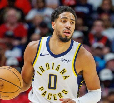 Indiana Pacers guard Tyrese Haliburton brings the ball upcourt with his right hand.