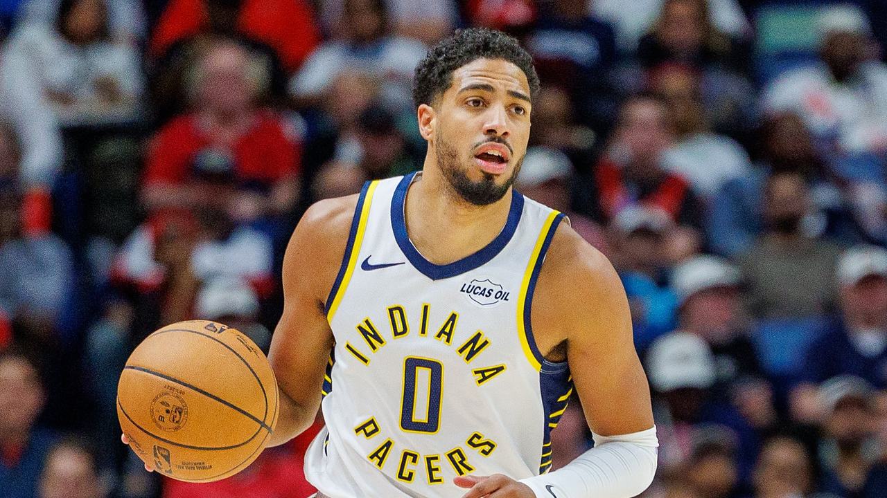 Indiana Pacers guard Tyrese Haliburton brings the ball upcourt with his right hand.