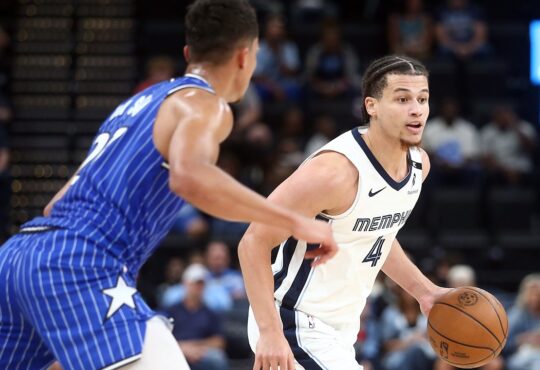 Memphis Grizzlies guard Walter Clayton Jr. dribbles with his left hand as an Orlando Magic defender guards him.